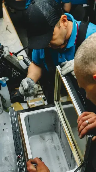 Technicians repairing a commercial freezer