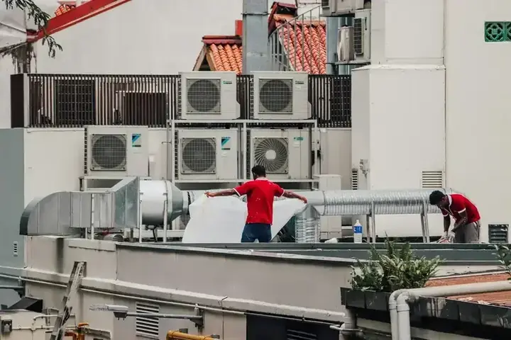 Technicians working on rooftop air conditioning units
